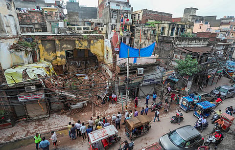 Local shop owners and residents near the debris of the house that collapsed due to heavy rains in Sabzi Mandi area, in New Delhi, Thursday, Aug. 1, 2024.