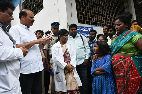 Minister Kolusu Parthasarathi interacting with the helpers of patients at the old GGH after they raised complaints about the poor maintenance of washrooms in Vijayawada on Tuesday. 