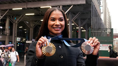 Two-time U.S. Olympic gymnast medalist Jordan Chiles shows her medals after ringing the closing bell at the Nasdaq MarketSite, in New York's Times Square.