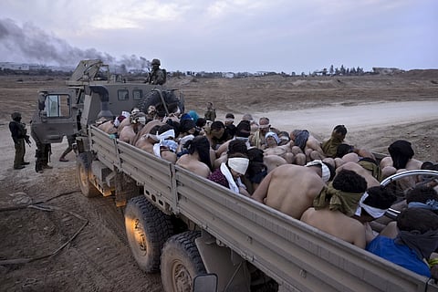 Representative Image: Israeli soldiers stand by a truck packed with bound and blindfolded Palestinian detainees, in Gaza on Dec 8, 2023.