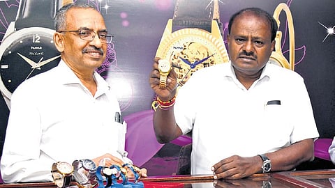 Union Minister H D Kumaraswamy checks out watches during a visit to the HMT facility in Bengaluru on Tuesday 