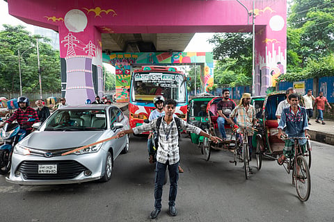 A student directs traffic in Dhaka, Bangladesh