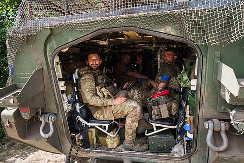 Ukrainian servicemen sit inside their APC after returning from Russian Kursk region, near Russian-Ukrainian border, Sumy region, Ukraine, Wednesday, Aug. 14, 2024. 