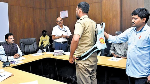 Officials get a demonstration on securing a child with safety harness 