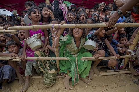 Rohingya Muslim children refugees, who crossed over from Myanmar into Bangladesh, wait squashed against each other to receive food handouts distributed to children and women by a Turkish aid agency, Oct 21, 2017, at a camp in Bangladesh.