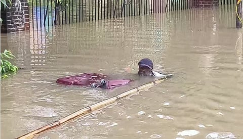 A man amidst heavy rain in Vadodra.