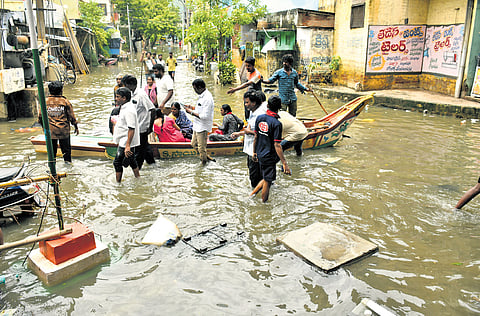 Flood victims of Old RR Pet moving to safer locations in a boat in Vijayawada 