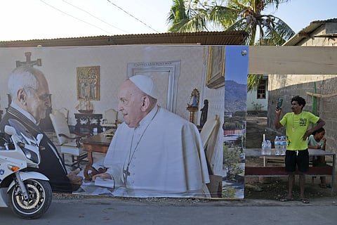 A man stands near a banner showing East Timor's President Jose Ramos-Horta, left, shaking hands with Pope Francis, ahead of the Pope's visit to the country, in Dili, Saturday, Sept 7, 2024.