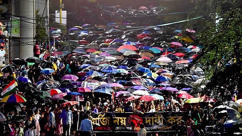 Junior doctors take part in a protest march to Swasthya Bhavan over the alleged sexual assault and murder of a trainee doctor, amid rain, in Kolkata.