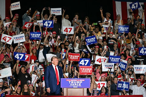 Supporters cheer as former US President and Republican presidential candidate Donald Trump arrives to speak during a campaign rally at the Expo World Market Center in Las Vegas