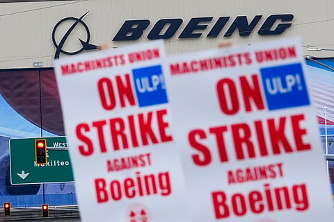 Boeing workers wave picket signs as they strike after union members voted to reject a contract offer, Sunday, Sept. 15, 2024, near the company's factory in Everett, Wash. 
