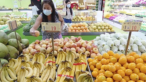 People buy fruit at a stall in Taipei, Taiwan, on Sept 20, 2021. 