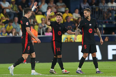 Barcelona's Pablo Torre, center, celebrates with teammates after he scoring his side's 3rd goal against Villarreal during a Spanish La Liga soccer match at the La Cerámica stadium in Villarreal.