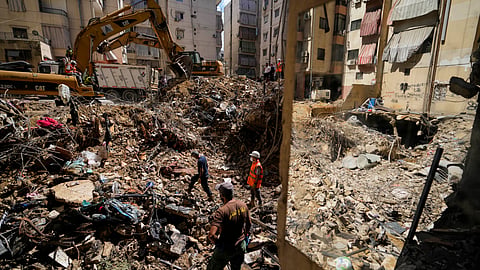 Emergency workers use excavators to clear the rubble at the site of  Israeli strike in Beirut's southern suburbs, Lebanon.