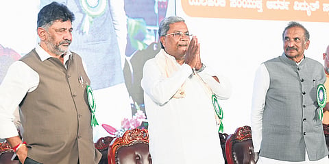 Chief Minister Siddaramaiah greets the gathering after inaugurating a 370MW combined cycle power plant in Bengaluru’s Yelahanka on Tuesday. Deputy Chief Minister DK Shivakumar and Energy Minister KJ George look on  