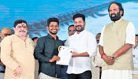 Chief Minister A Revanth Reddy hands over an appointment letter to a newly recruited  AEE at Jala Soudha in Hyderabad.