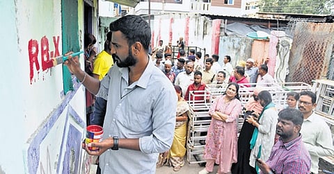 An official marks “RB-X” on a house, as part of the survey of structures along Musi riverbed at Chaderghat  in Hyderabad on Thursday 