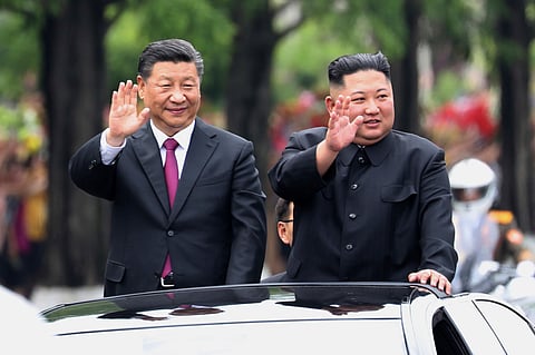 In this photo released by China's Xinhua News Agency, visiting Chinese President Xi Jinping, left, and North Korean leader Kim Jong Un wave from an open top limousine as they travel along a street in Pyongyang, North Korea, on June 20, 2019. 