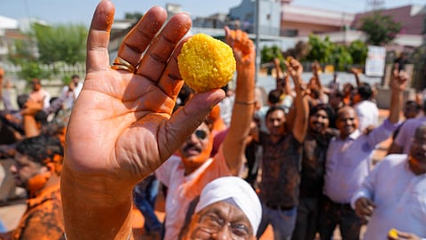 A supporter shows a ‘laddoo’ amid celebration after Congress candidate from Julana constituency Vinesh Phogat won her maiden election in the Haryana Assembly elections, in Jind district, Haryana.
