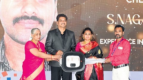 An employee receives a key to a car at an event on Saturday 