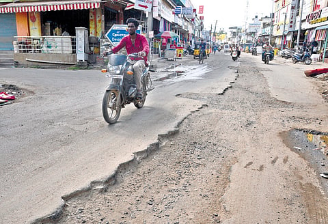 Damaged condition of Kamarajar Salai following drainage work 