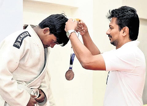 Deputy CM Udhayanidhi Stalin presents medal to an athlete.