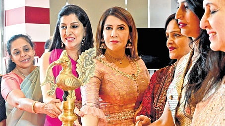 Veena Jain (centre) lights the lamp at a jewellery exhibition.