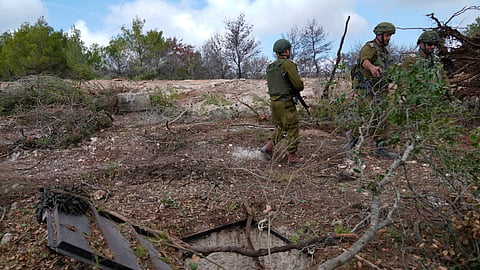 Israeli soldiers display what they say is an entrance to a Hezbollah tunnel found during their ground operation in southern Lebanon, near the border with Israel, Sunday, Oct. 13, 2024. 