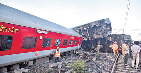 Indian railway workers restoring the site by pushing the coaches of the Mysuru-Darbhanga Bagmati Express train derailed at the Kavaraipettai Railway Station. 