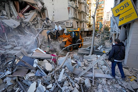Rescue workers use a bulldozer to remove rubble of destroyed buildings at the site of an Israeli airstrike on Sunday night that hit several branches of the Hezbollah-run al-Qard al-Hassan in Beirut's southern suburb, Lebanon.
