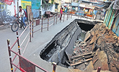 A boy rides his bicycle past the caved-in road at Chaknavadi 
in Goshamahal, Hyderabad, on Wednesday 
