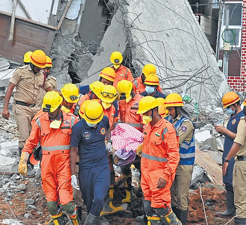 NDRF and fire personnel recover a body from the site of the collapse in Babusapalya on Wednesday. Search operations for the trapped labourers will continue
