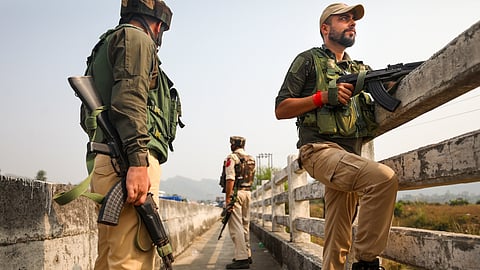  Police personnel stand guard during a search operation after a terror attack in Batal area of Akhnoor Sector, J & K.