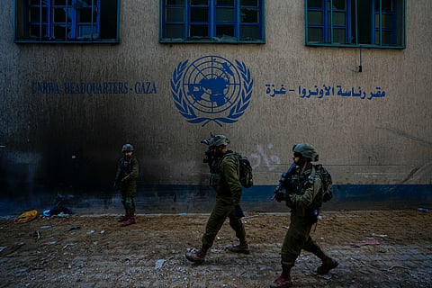 Israeli soldiers take position as they enter the UNRWA headquarter where the military discovered tunnels underneath of the U.N. agency that the military says Hamas militants used to attack its forces during a ground operation in Gaza, 