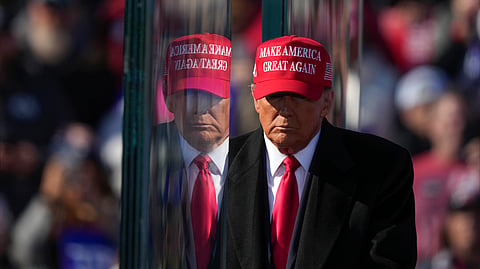 Republican presidential nominee former President Donald Trump is reflected in the bullet proof glass as he finishes speaking at a campaign rally in Lititz, Pa.