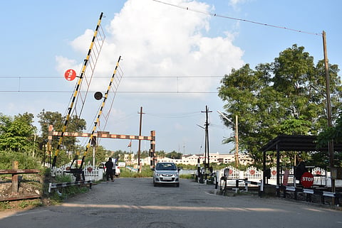 Vehicles crossing the railway track at the NGGO colony in Thudiyalur in Coimbatore district on Sunday.