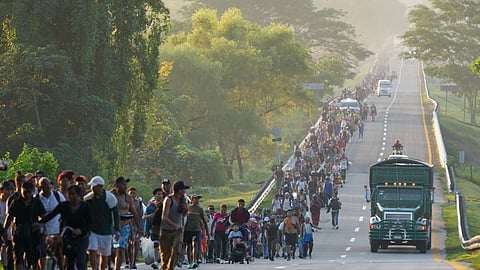 Migrants walk along the highway in Huixtla, southern Mexico, heading toward the country's northern border and ultimately the United States.