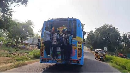 A picture of students hanging in the back ladder of the over crowded private bus near Pulikarai.