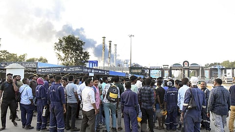 Workers wait outside after an explosion at the Indian Oil Corporation (IOCL) refinery in  Vadodara