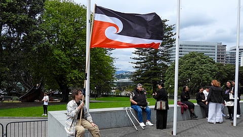 A protester against the Treaty Principles Bill sits outside Parliament in Wellington, New Zealand.