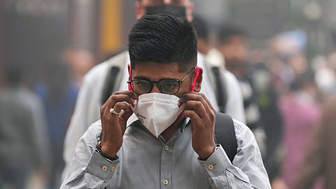 A commuter adjusts his face mask as air quality continues to remain poor, in New Delhi, Monday, Nov. 18, 2024. 