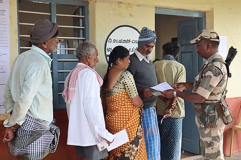 Voters stand in a long queue to exercise their franchise in Channapatna 