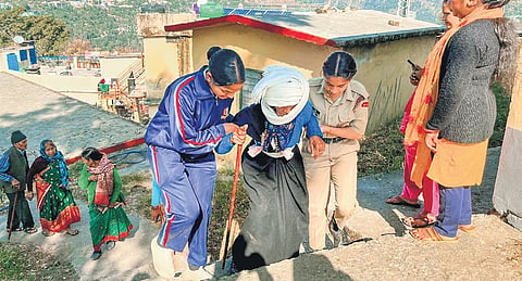 An elderly voter being assisted to a polling booth in Kedarnath constituency.