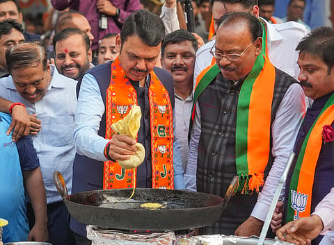 Maharashtra DCM Devendra Fadnavis prepares 'jalebi' at the BJP office as State BJP incharge Chandrashekhar Bawankule look on during celebrations after party's win in the Assembly elections, in Mumbai, Saturday, Nov. 23, 2024.