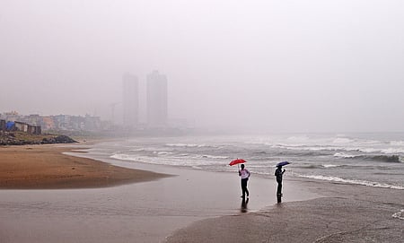People enjoying the rain near Kasimedu Fishing Harbor beach as cyclonic heavy rainfall sweeps through Chennai and coastal Tamil Nadu