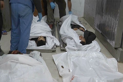 People stand near bodies on the ground inside the emergency department at Nasser hospital in Khan Younis after an Israeli airstrike on Saturday, Nov. 30, 2024.