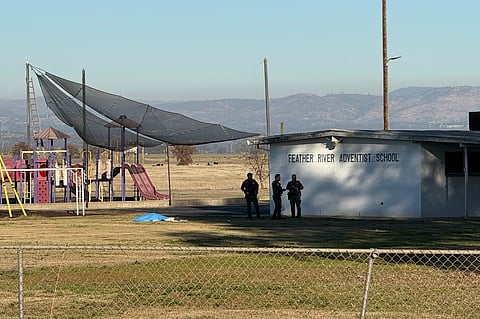 Police officers stand near a body covered by a tarp outside of Feather River Adventist School after a shooting Wednesday, Dec. 4, 2024, in Oroville, Calif.