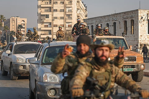 Syrian opposition fighters ride along the streets in the aftermath of the opposition's takeover of Hama, Syria, Friday, Dec. 6, 2024.
