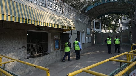 Security personnel stand outside the  DPS RKPuram after Receives Bomb threat in New Delhi on Monday.  