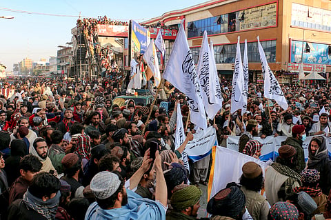 Afghan nationals wave Taliban flags during celebrations in Khost province on December 8, 2024, to mark the end of Syrian dictator Bashar al-Assad's rule after rebel fighters took control of the Syrian capital Damascus overnight. 
